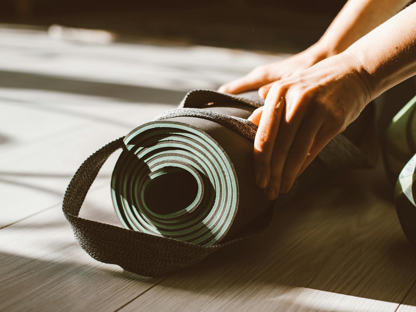 Pilates mat work on a linen floor in soft morning light.
